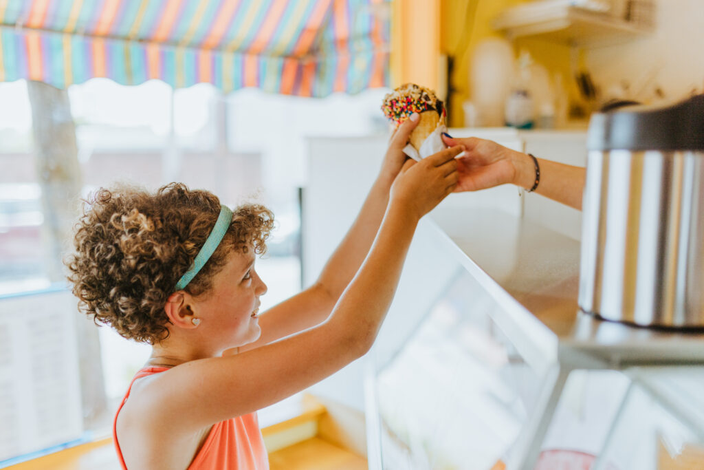 Young girl buying an ice cream cone
