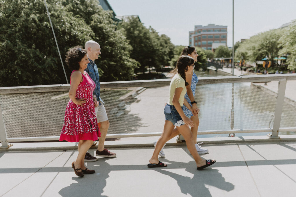 family of four walking across bridge on Carroll Creek