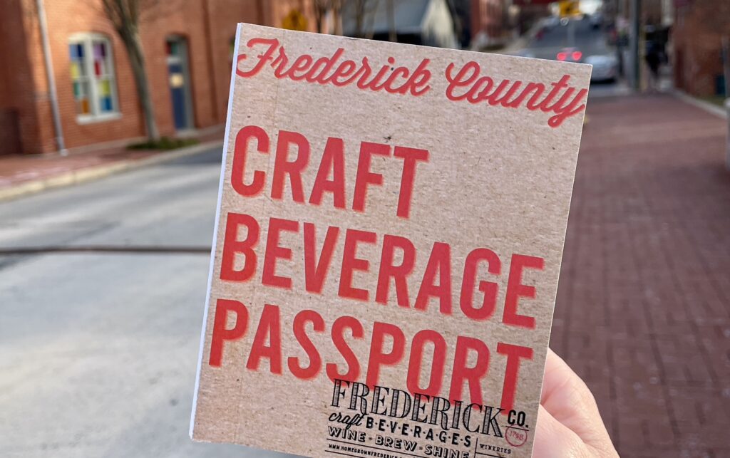 person holding craft beverage passport